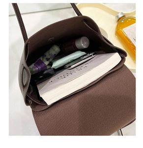 Internal view of dark brown tote bag showing large capacity for books and cosmetics