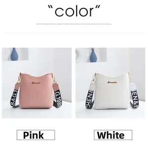 Close-up of pink and white crocodile pattern crossbody bags with printed fabric straps