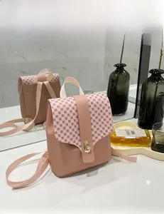 Detail of mini pink crossbody bag with retro print flap and golden twist lock closure