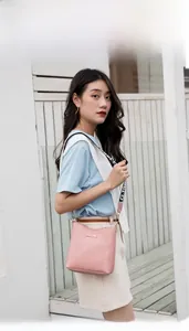 Detail of pink crocodile pattern crossbody bucket bag with wide jacquard shoulder strap