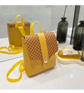 Detail view of yellow crossbody phone bag with vintage geometric print and gold metal twist lock