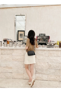Detail of black quilted crossbody bag with fringe tassel and LOVE slogan strap