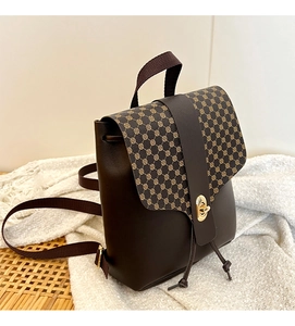 Close-up of vintage mini backpack showing turn-lock and brown geometric pattern