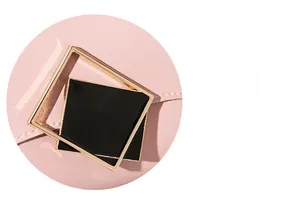 Detail of golden square metal buckle on pink leather handbag with textured finish