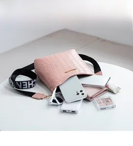Pink croc-effect bucket bag with logo strap showing spacious interior for essentials