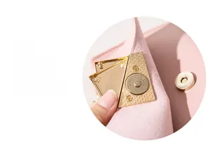 Detail view of the pink leather bag featuring a gold magnetic snap and textured metal lock
