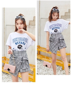 Detail of white cotton T-shirt with graphic print and grey plaid mini skirt set