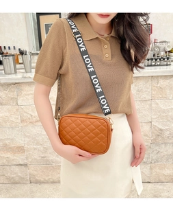 Detailed view of brown quilted crossbody bag with stylish LOVE lettered wide strap