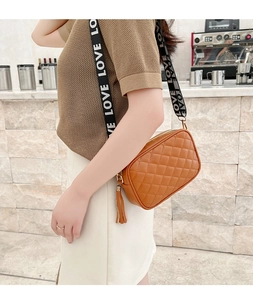 Brown quilted crossbody bag with stylish LOVE letter strap shown on shoulder