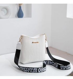 Close-up of white crocodile pattern bucket bag with detachable wide canvas logo strap