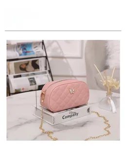 Sac à bandoulière rose matelassé avec nœud blanc et dimensions de 22x12x7cm
