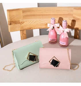 Detail of mint green and pink PU leather flap bags with geometric gold buckles and chains