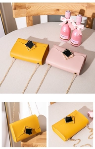 Detail of yellow and pink crossbody bags with gold square buckles and chain straps