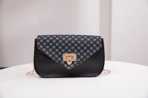 Elegant navy pattern crossbody bag with black leather and gold chain strap in studio view