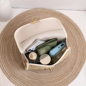 Woven straw crossbody bag with gold chain and interior showing spacious daily storage