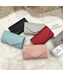 Detailed top view of various colorful envelope wallets on soft plush background
