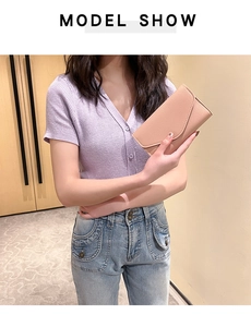 Model holding apricot pink long bifold wallet with soft leather texture and card slots