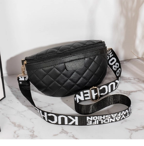 Detail der schwarzen Stepptasche mit breitem, bedrucktem Canvas-Schultergurt im Fokus