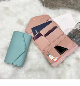 Detail view of pink bifold faux leather wallet with passport slot and card holders