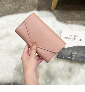Detailed view of dusty pink envelope clutch wallet with cross-grain leather texture