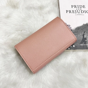 Close-up of dusty rose lychee grain leather texture on a stylish women's wallet