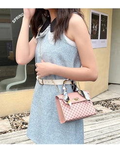 Pink crossbody bag with monogram pattern and silk scarf wrapped around handle