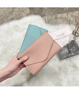 Detailed view of long PU leather wallets in mint and pink with envelope flap design