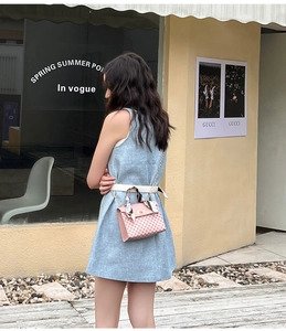 Pink checkered crossbody bag with silk scarf handle detail worn with a tweed dress