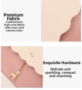 Detail der rosa-weißen Ledertasche mit goldenem Hirschanhänger und Metallschnalle