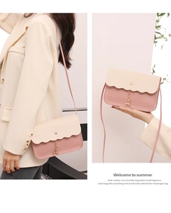Details der rosa-beigen Mini-Umhängetasche mit Wellenkante und Goldhirsch-Anhänger
