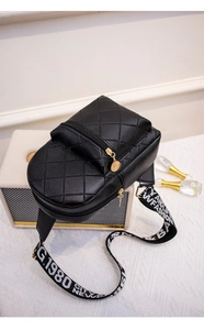 Detailed view of black quilted faux leather crossbody bag with lettered wide strap