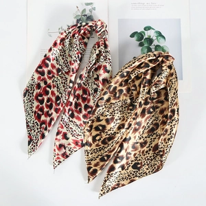 Close-up of leopard print silk hair scarves with fine stitching and smooth satin texture
