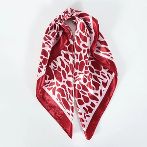 Detailed view of red and white giraffe print satin scarf with smooth silk finish