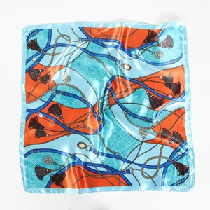 Detail of silk-like scarf featuring orange and blue nautical rope and tassel patterns