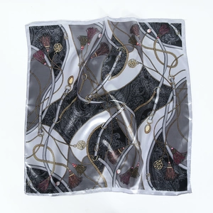 Flat lay of 60cm square silk scarf featuring golden chain and belt prints on white background
