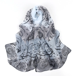 Detail view of light chiffon floral scarf with blue and grey rose pattern on white background