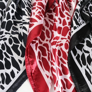 Elegant satin scarf featuring chic giraffe animal print and smooth glossy texture