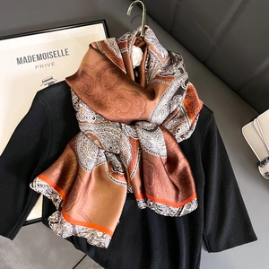 Écharpe en soie rétro française avec imprimé cachemire marron et orange sur un haut noir