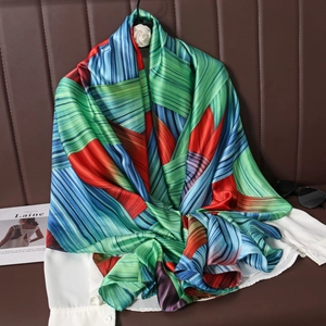 Artistic geometric print satin scarf draped over white shirt in a professional setting
