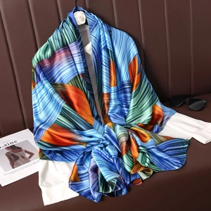Satin silk scarf with abstract geometric stripes styled on a shirt with sunglasses