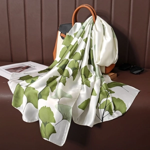 Elegante sciarpa in seta con stampa di foglie di ginkgo verde su una borsa di lusso