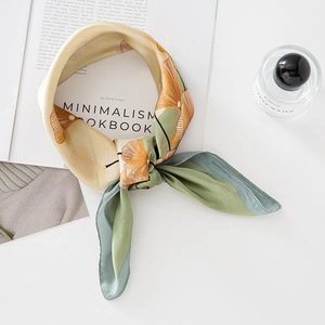 Knot-tied silk scarf featuring vintage ginkgo leaf patterns in mustard and sage green