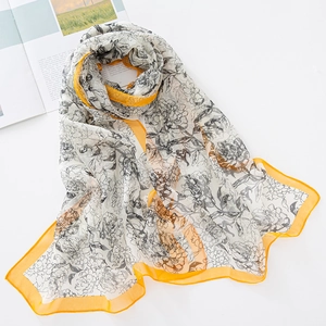 Detalle de bufanda de gasa floral con borde amarillo y textura suave de georgette