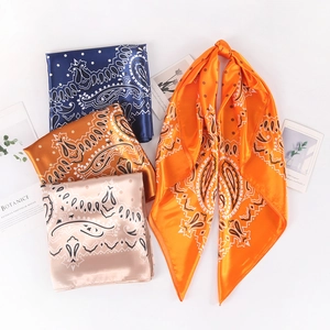 Silk-satin 90cm square paisley scarves in navy, orange, and gold colors set on white background