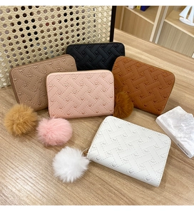 Detailed set of mini quilted wallets with heart patterns and plush ball pendants