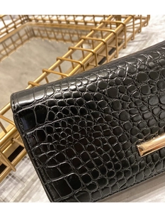 Vue détaillée du portefeuille en cuir noir à motif crocodile avec garniture dorée