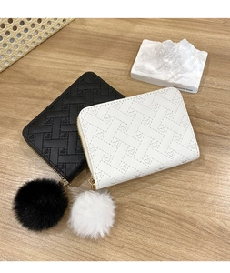 Detail of mini quilted purses with heart embossing and decorative fluffy pom-pom charms