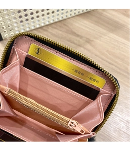 Internal detail of a mini wallet showing pink lining, card slots and zipper pocket
