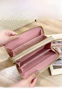Close-up of the multi-slot interior storage and double zippers in this pink long wallet