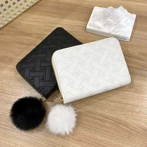 Mini quilted card wallets with heart patterns and plush pompom charms in black and white